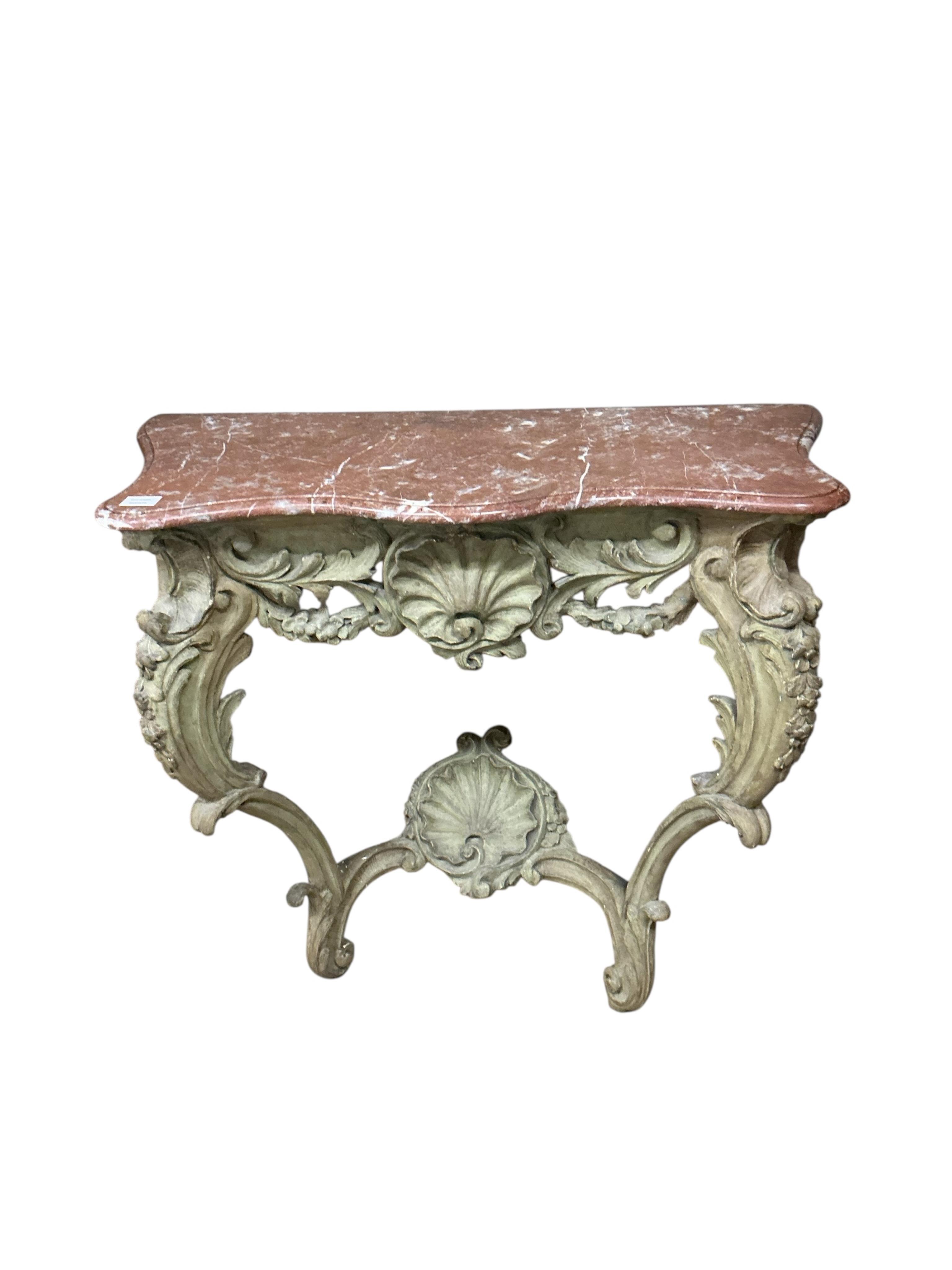 A Louis XV style console table the rouge marble serpentine top raised on a foliate, shell and floral swagged base with two cabriole style supports, width 100cm, depth 45cm, height 90cm